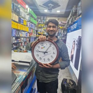 Happy Retailer With Branded Wall Clock